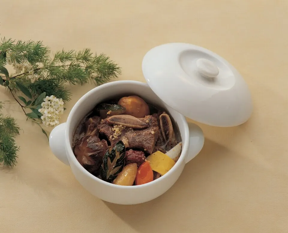 흰 뚝배기에 담긴 소갈비찜. 갈비와 함께 밤, 당근, 표고버섯, 대추, 지단 고명이 올라가 있는 모습