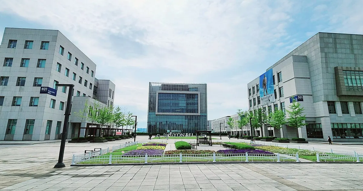 연세대학교 국제캠퍼스의 현대식 건물들과 잔디 광장이 보이는 맑은 날 풍경
