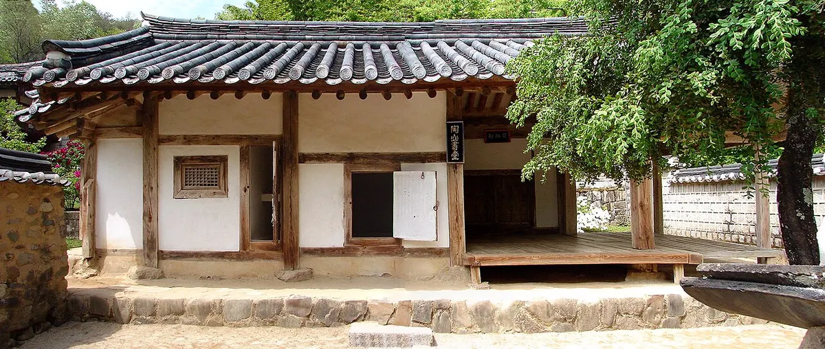 도산서원 안의 도산서당 건물. 기와지붕 아래 흰 벽과 나무 기둥, 툇마루가 보이고 옆에 나무 한 그루가 서 있다